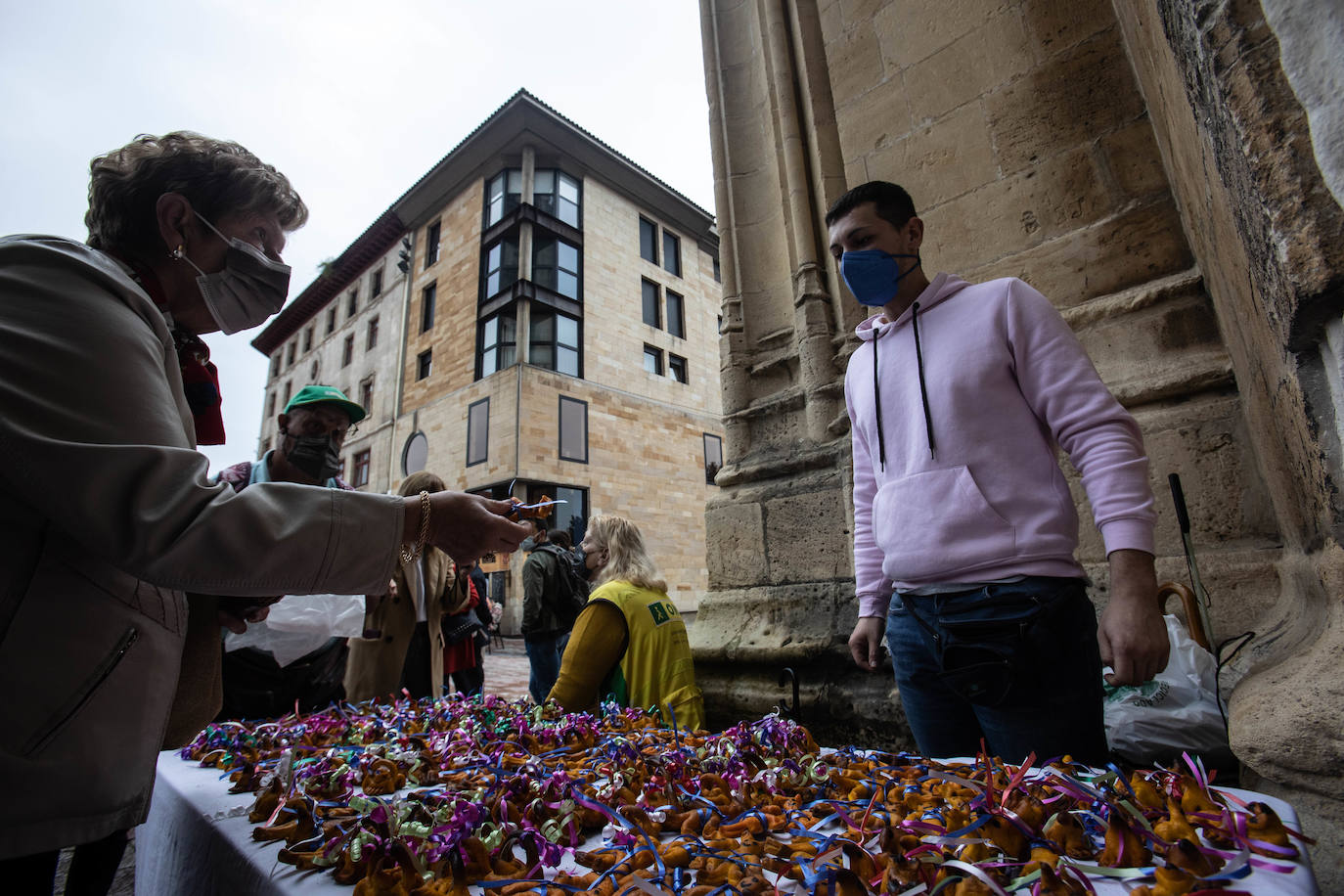 El reparto del bollo entre los socios de la SOF se llevó a cabo en la Plaza de España y les paxarines, las tradicionales figuras de pan, volvieron a la puerta de la Catedral tras el parón por la pandemia