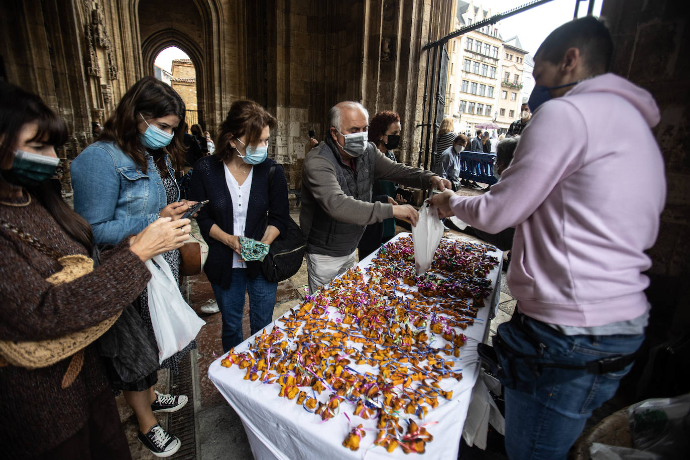 El reparto del bollo entre los socios de la SOF se llevó a cabo en la Plaza de España y les paxarines, las tradicionales figuras de pan, volvieron a la puerta de la Catedral tras el parón por la pandemia