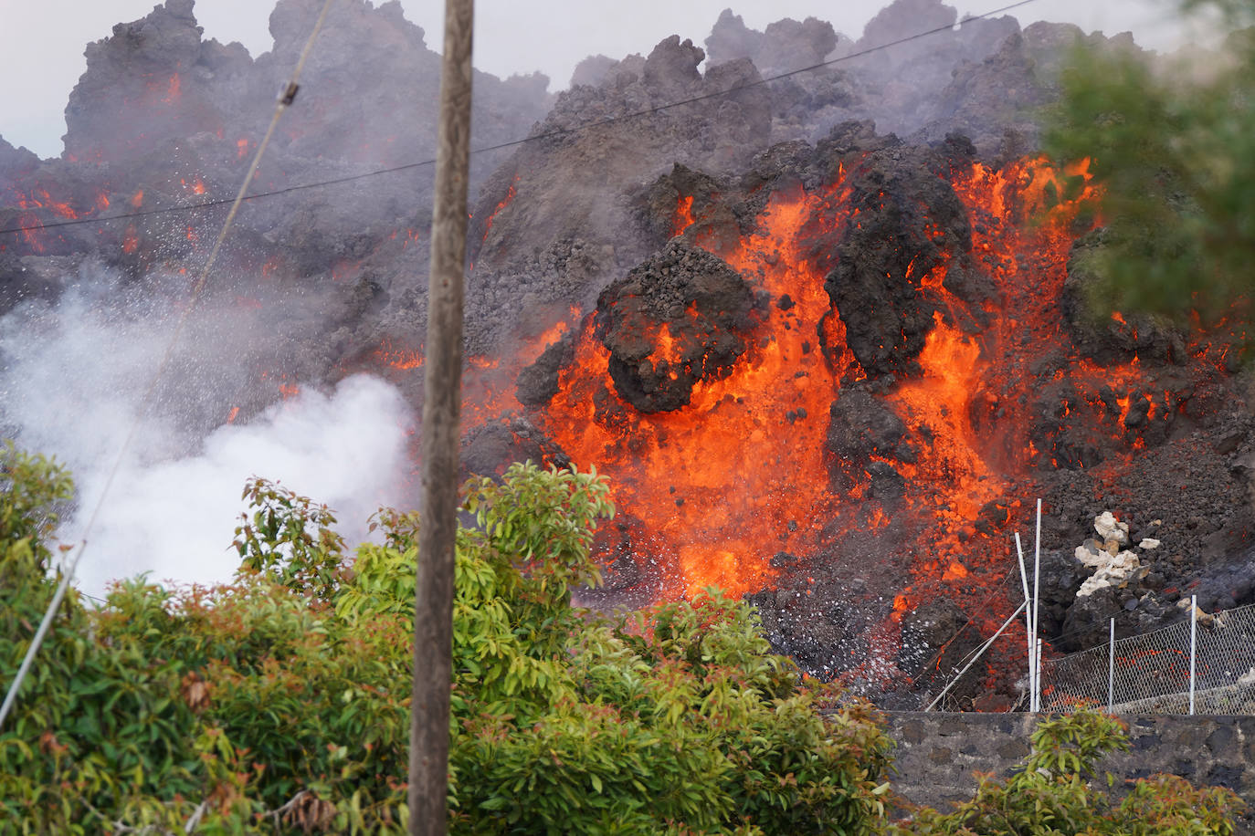 La colada de lava provocada por la erupción del volcán de Cumbre Vieja avanza arranso casas y cultivos.