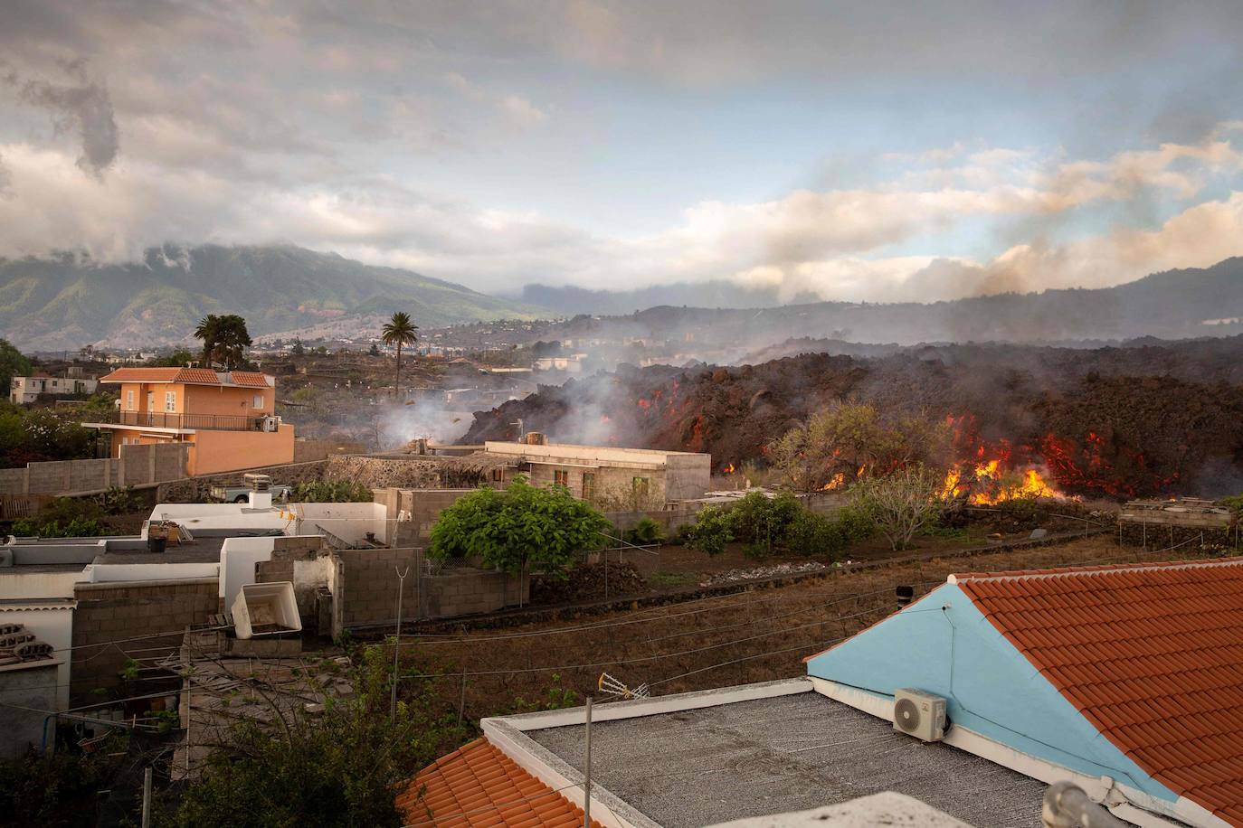 La colada de lava provocada por la erupción del volcán de Cumbre Vieja avanza arranso casas y cultivos.