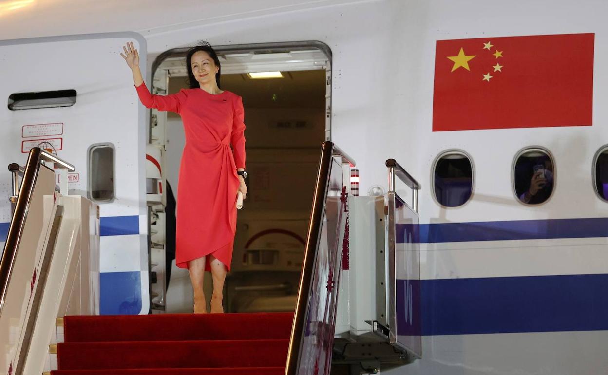 Meng Wanzhou saluda desde la puerta del avión, este sábado, nada más aterrizar en el aeropuerto de Shenzhen. 