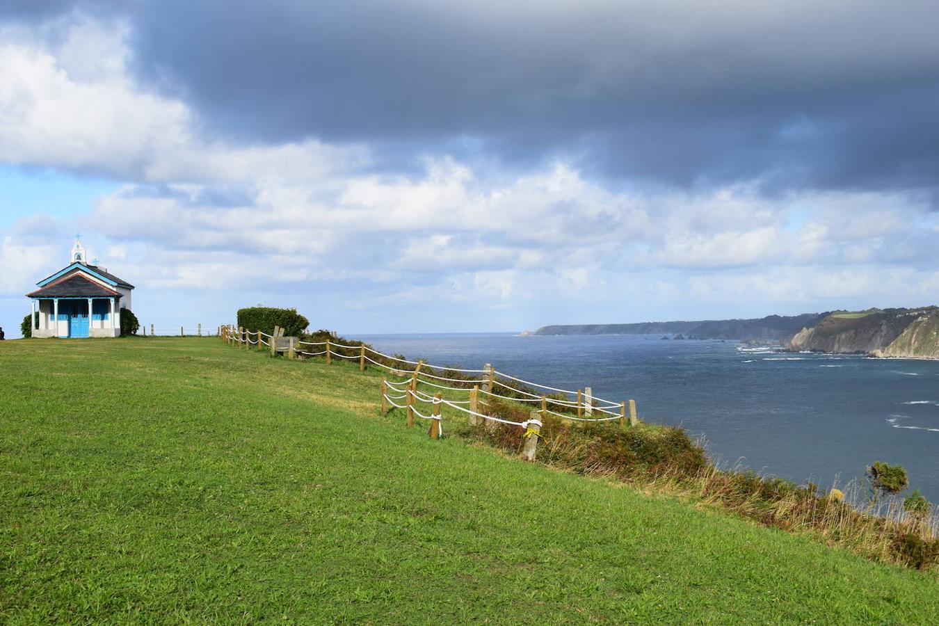 En el pueblo de Cadavedo y en pleno concejo de Valdés, es donde esta vez te acercamos y donde se encuentra el mirador de La Regalina, uno de esos lugares especiales que pueden encontrarse a ras de la costa asturiana y desde el que podrás disfrutar de una de las mejores vistas del occidente asturiano y del litoral. Un estupendo balcón en el que los pastos verdes tiñen de color un paisaje único y en el que la gran protagonista es una pequeña ermita de 1931 y dos hórreos, los cuales se encargan de presidir los acantilados de más de 70 metros sobre los que se ubica este mirador. Una panorámica única que nos acerca a ese Paisaje Protegido de la Costa Occidental Asturiana en el que se fusionan a la perfección mar y montaña, regalándonos unas vistas inigualables de la Playa de Cadavedo y Ribón y al arenal de Churín.