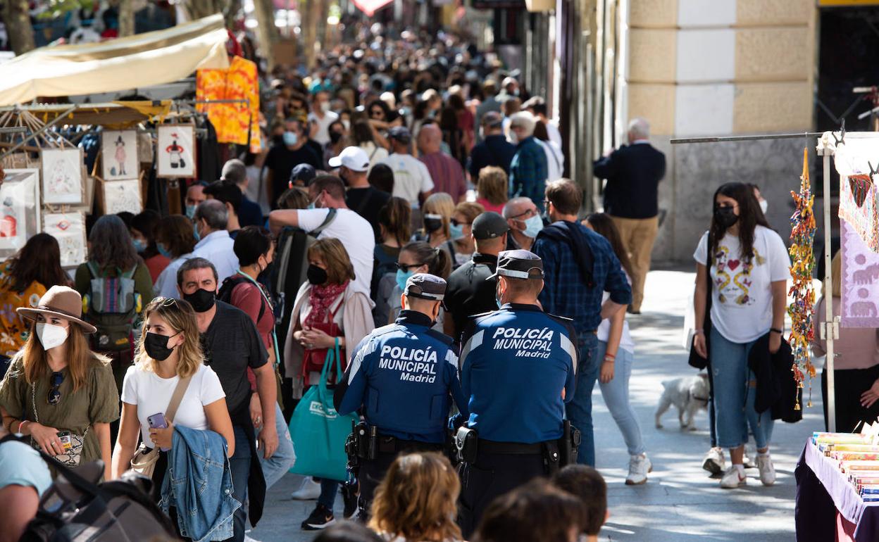 Miles de visitantes pasean por El Rastro de Madrid este domingo.