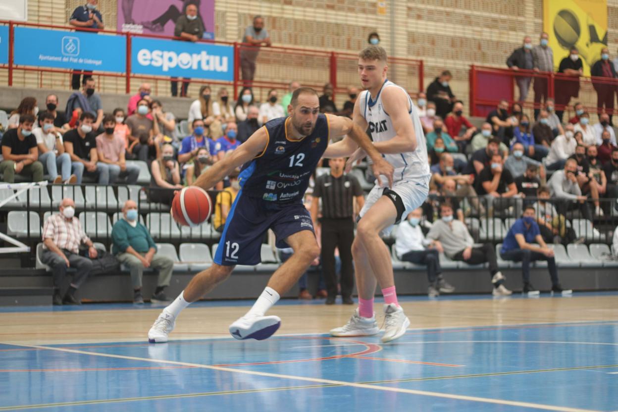 Óliver Arteaga entra a canasta ante el marcaje de Kriss Helmanis. 