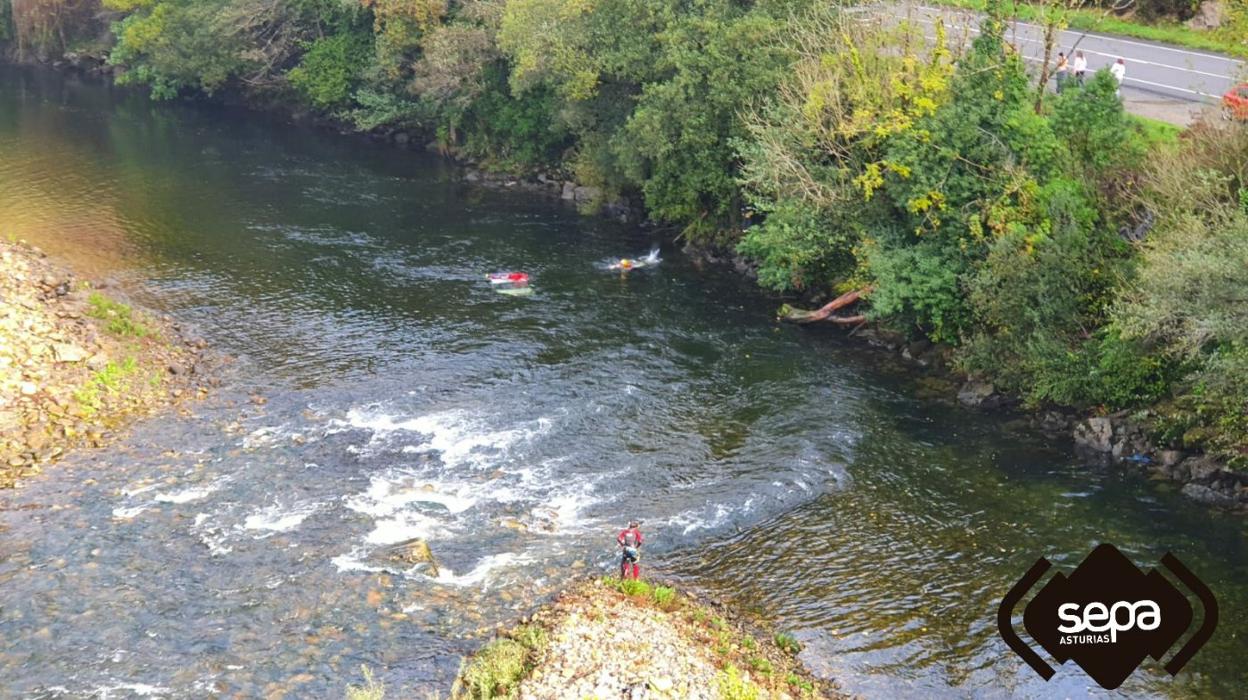El automóvil, de color claro, quedó completamente sumergido en una zona situada entre Santiago de la Barca y Requejo, en la que el Narcea tiene una pequeña isla central, que acelera la velocidad de las aguas. Arriba a la derecha, la calzada de la AS-15 y la zona por la que, presumiblemente, el vehículo se precipitó al cauce fluvial . 