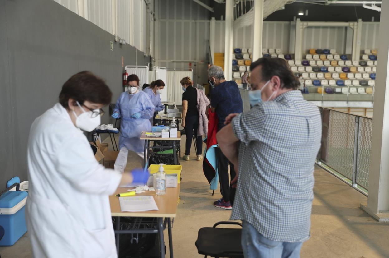 Varias personas reciben su vacuna contra la gripe en el inicio de la campaña de 2020, en el pabellón deportivo de La Tejerona. 