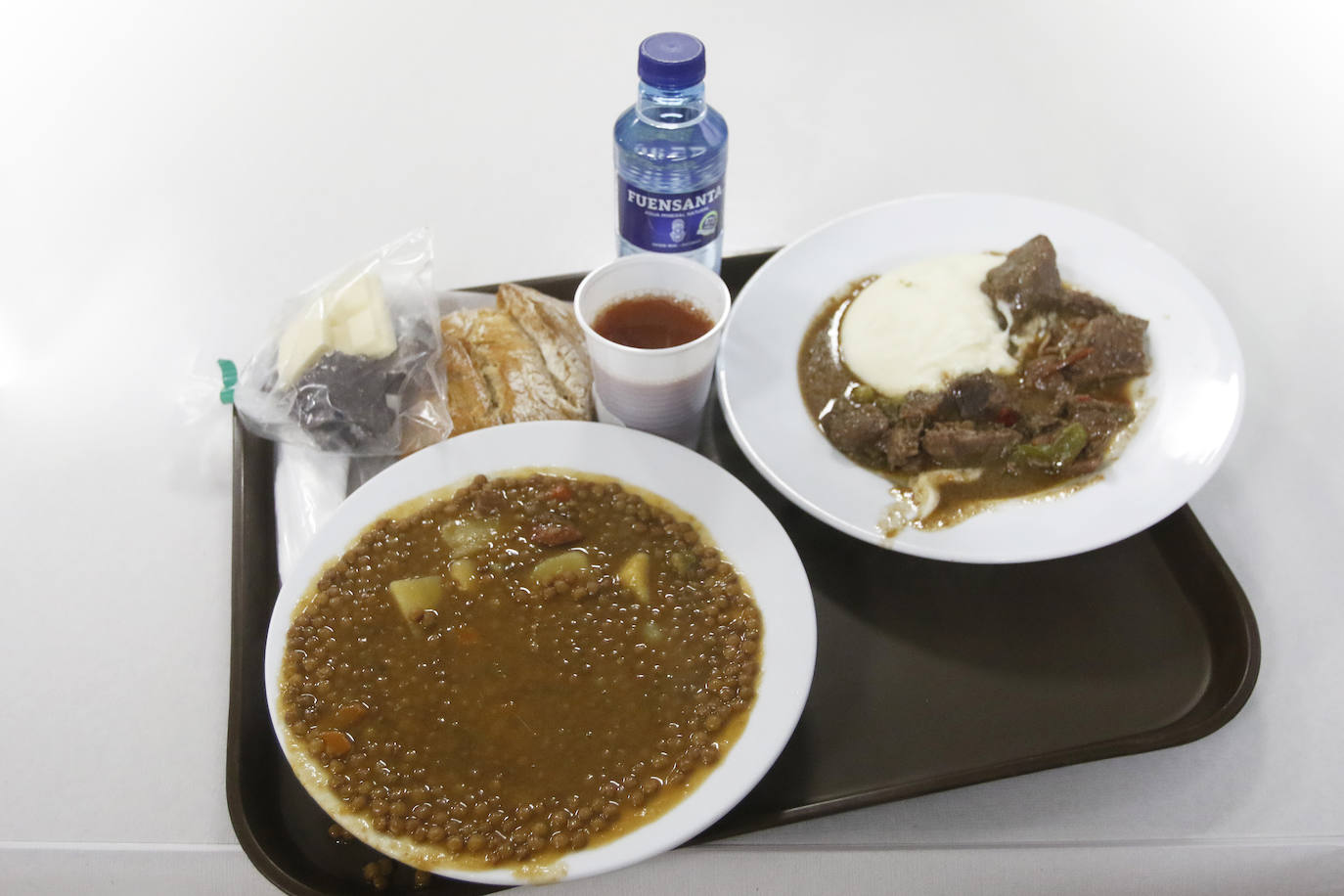 Tras más de un año y medio sin poder prestar este servicio, la Cocina Económica abre sus puertas de nuevo. El menú de hoy: lentejas y carne guisada.