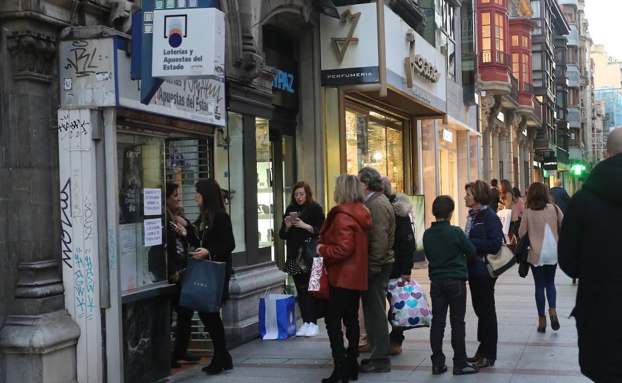  Cola ante una administración de la calle Corrida, Gijón, para comprar Lotería de Navidad.