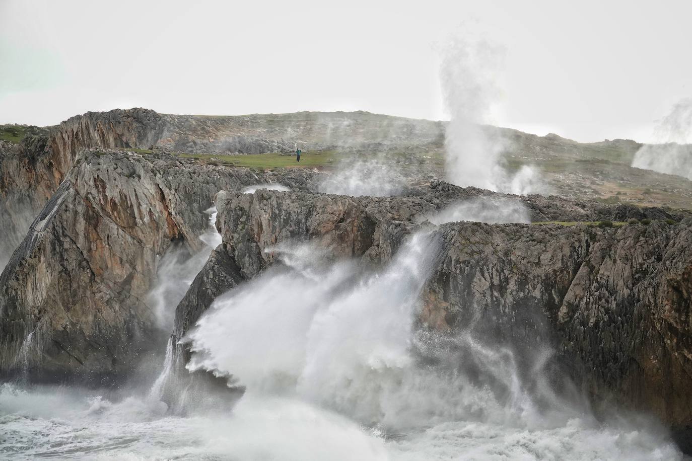 Las impresionantes olas y la fuerza del mar atraen a los curiosos, que pasean por los acantilados de Llanes y Ribadesella aprovechando para capturar el momento con sus fotografías. 