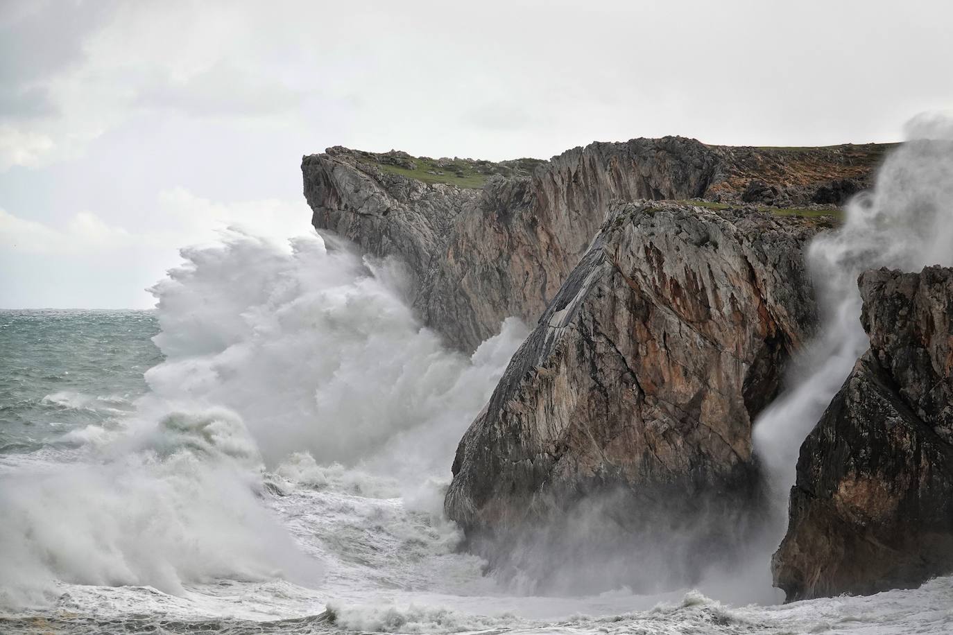 Las impresionantes olas y la fuerza del mar atraen a los curiosos, que pasean por los acantilados de Llanes y Ribadesella aprovechando para capturar el momento con sus fotografías. 