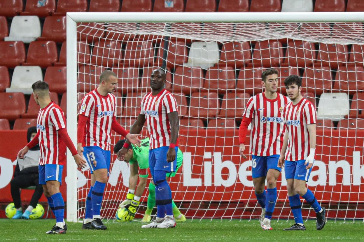 Mariño recoge el balón de la portería mientras los jugadores buscan explicación al gol del Fuenlabrada tras un despiste defensivo. 