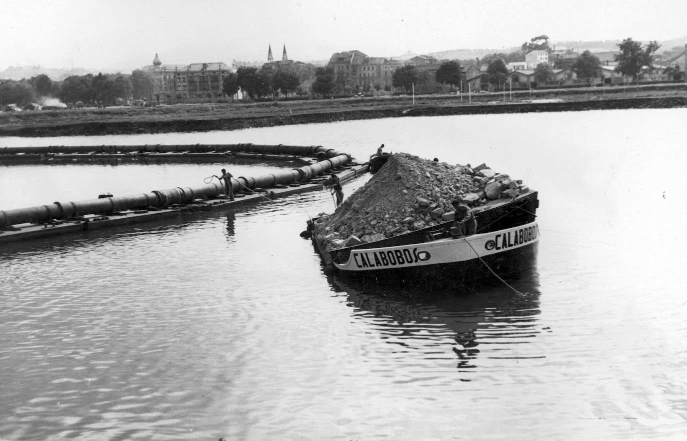 Traslado en gabarra del material de relleno desde el muelle local a punto de vertido