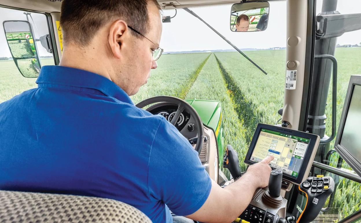 Un agricultor en un tractor equipado con tecnología digital. 