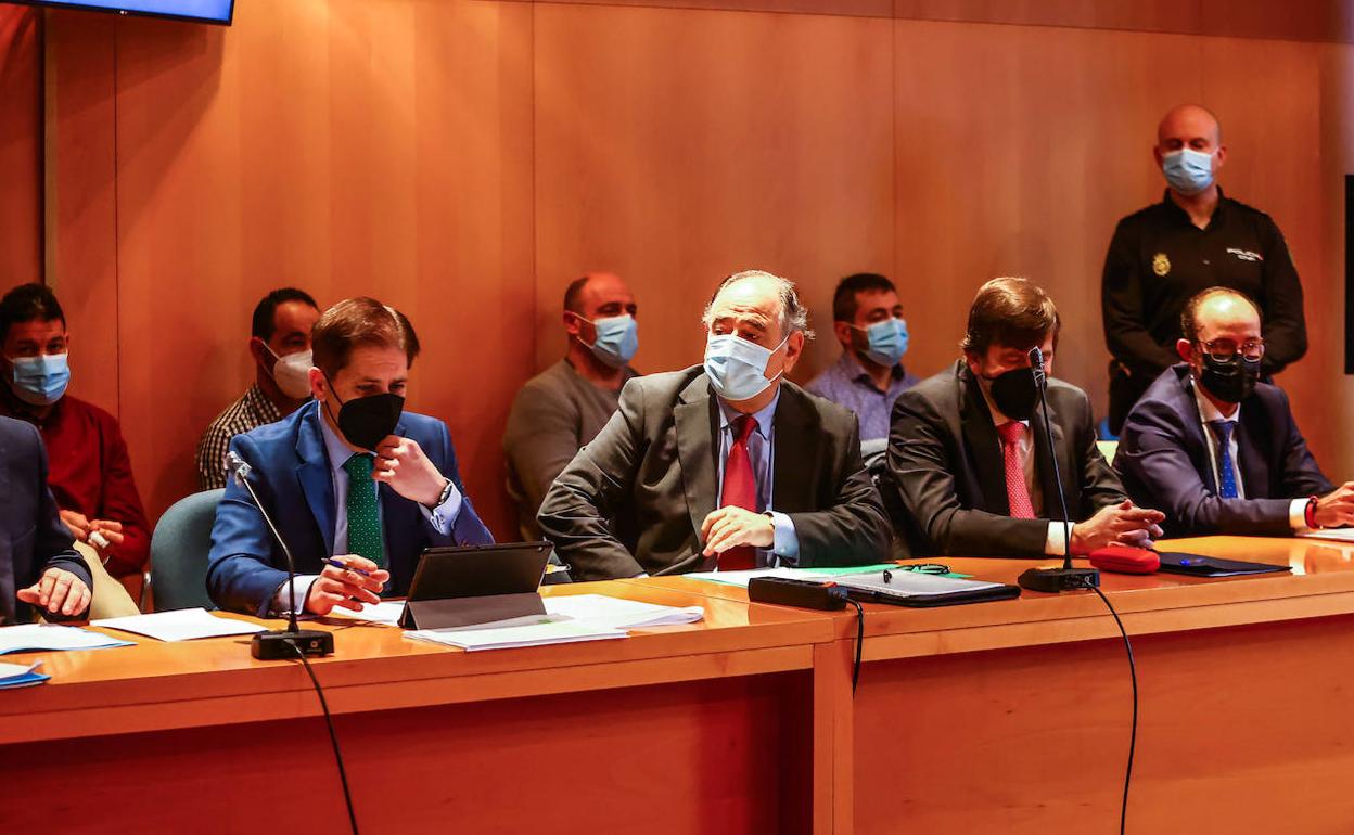 Acusados y sus abogados, durante el juicio.