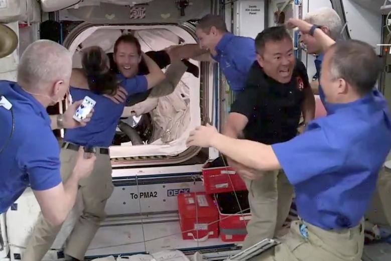 El astronauta de JAXA, Akihiko Hoshide, de Japón, es recibido por su compatriota, el astronauta Soichi Noguchi, mientras él y el astronauta de la ESA Thomas Pesquet de Francia son recibidos cuando llegan a bordo de la Estación Espacial Internacional, después de atracar la cápsula que orbita la Tierra, el 24 de abril.