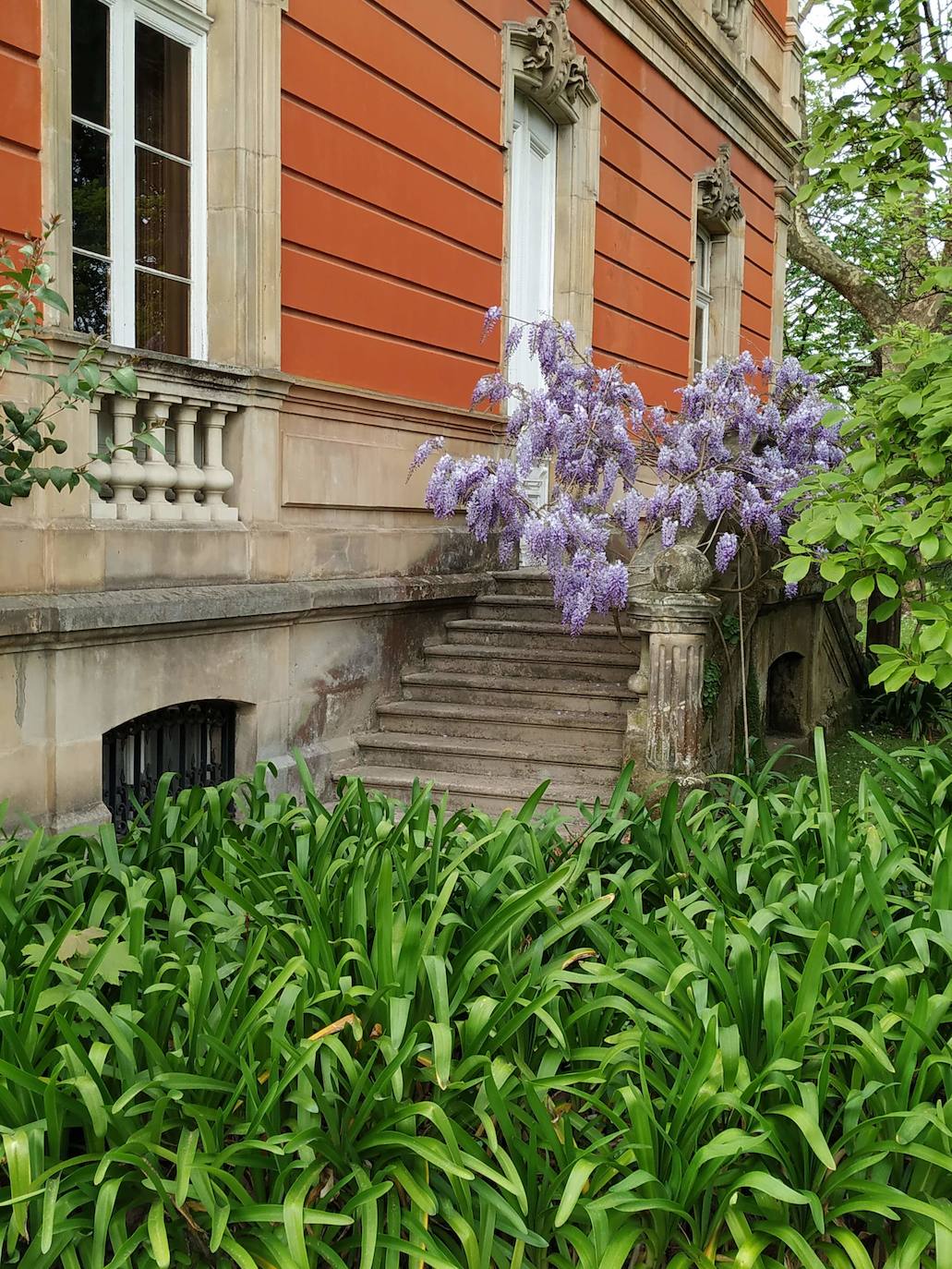 La configuración del jardín se establece a partir de unos enormes e irregulares parterres, impuestos por una red caminera sinuosa de grijo para favorecer el drenaje. Desde la imponente puerta principal se accede a través de un pasillo orlado por bojes donde nos saludan sus dos míticos leones blancos que fueron traídos de un palacio de Cáceres y a sus pies se disponen sendos parterres circulares que se hermosean con flores de temporada.