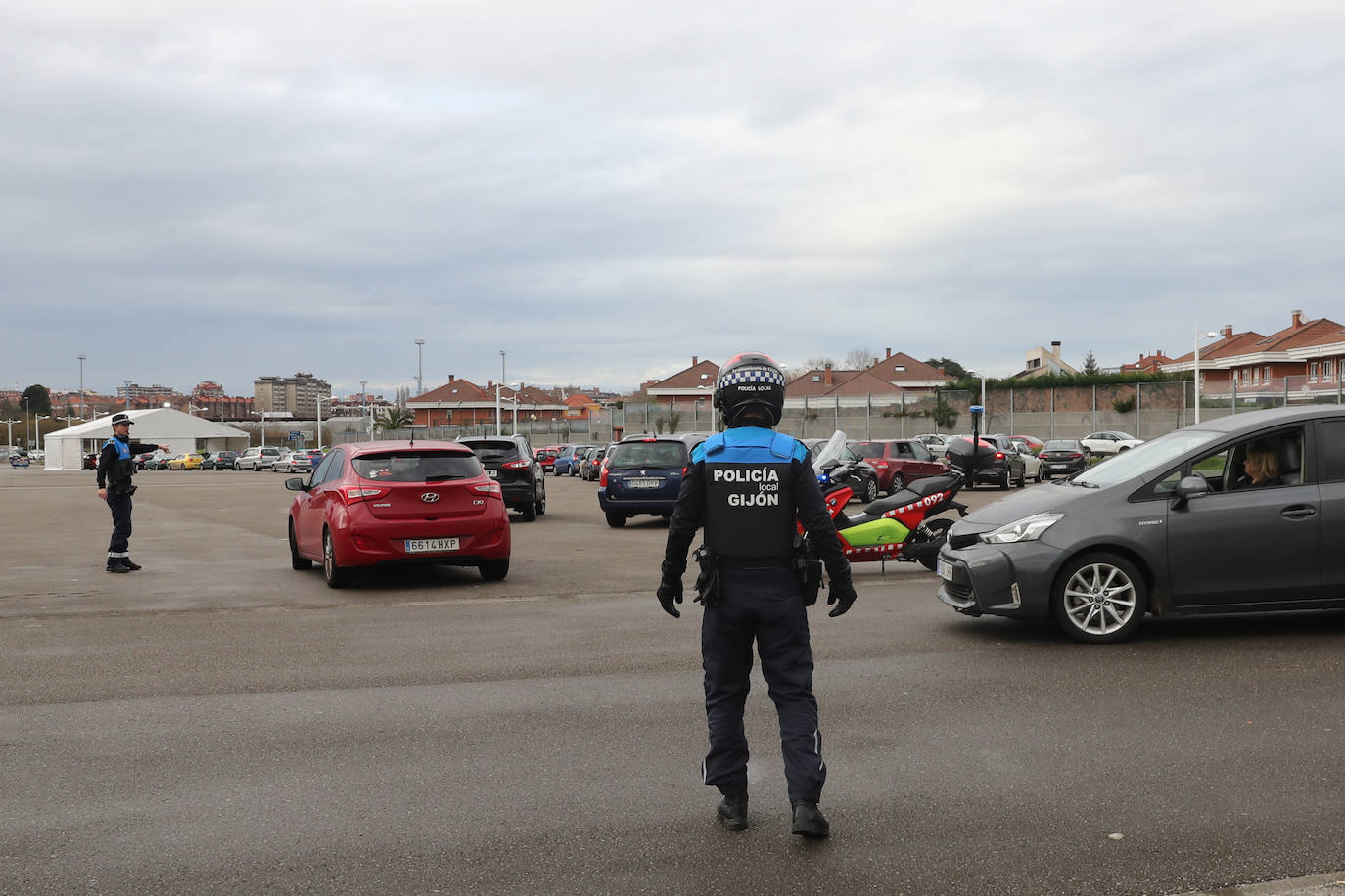 La actividad está siendo intensa en los autocovid de Gijón. Este mismo jueves, agentes de la Policía Local han tenido que acudir al instalado en la Marina Civil para formar una suerte de circuito y ordenar el tráfico. 