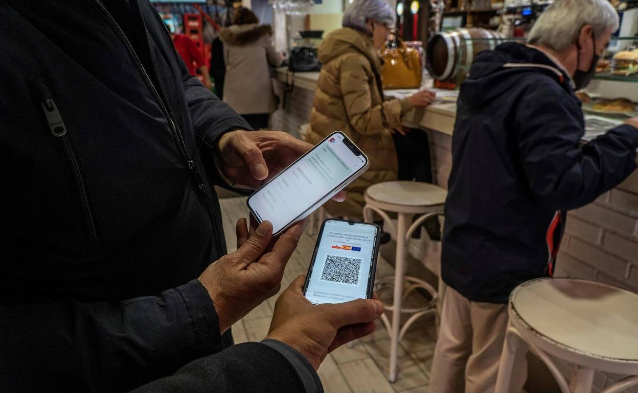 Dos personas muestran el pasaporte covid 