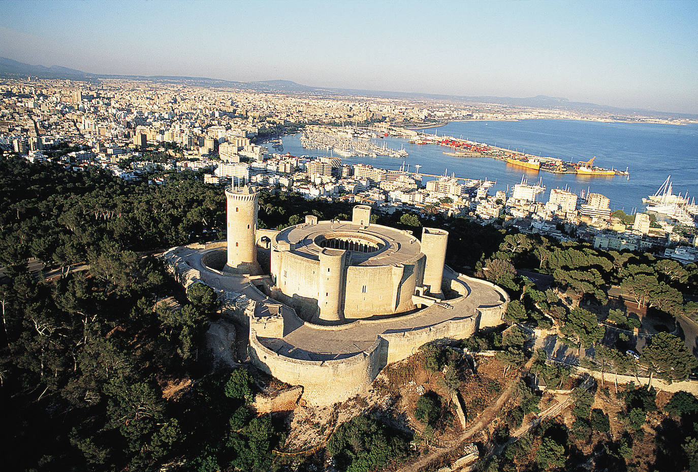 Marzo: Castillo de Bellver (Palma de Mallorca) | Fue construido a principios del s.XIV por orden del rey Jaime II de Mallorca. Es una fortificación de estilo gótico y se encuentra en un monte de 112 metros sobre el nivel del mar, una zona boscosa desde donde se contempla perfectamente la ciudad y el puerto. Hace honor a su nombre en catalán por las bellas vistas que tenían los habitantes del castillo. Una de sus peculiaridades es que es uno de los pocos castillos europeos de planta circular y es el más antiguo de todos ellos. 