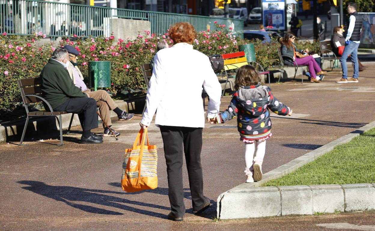 Una abuela y su nieta pasean por un parque de Gijón. 