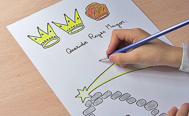 Un niños escribiendo su carta a los Reyes Magos 