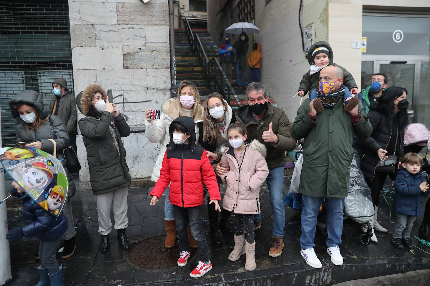 Los Reyes Magos atracaban en el puerto de Gijón bajo la lluvia sobre las 11 de la mañana mientras centenares de niños coreaban lo nombres de Sus Majestades.