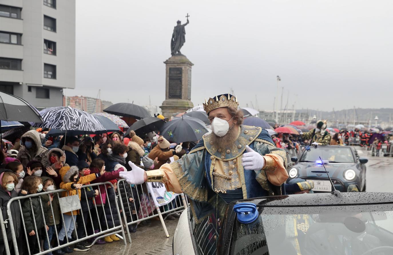 Los Reyes Magos atracaban en el puerto de Gijón bajo la lluvia sobre las 11 de la mañana mientras centenares de niños coreaban lo nombres de Sus Majestades.