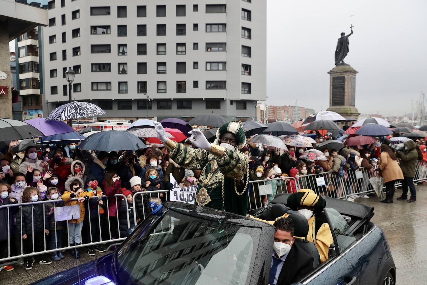 Los Reyes Magos atracaban en el puerto de Gijón bajo la lluvia sobre las 11 de la mañana mientras centenares de niños coreaban lo nombres de Sus Majestades.