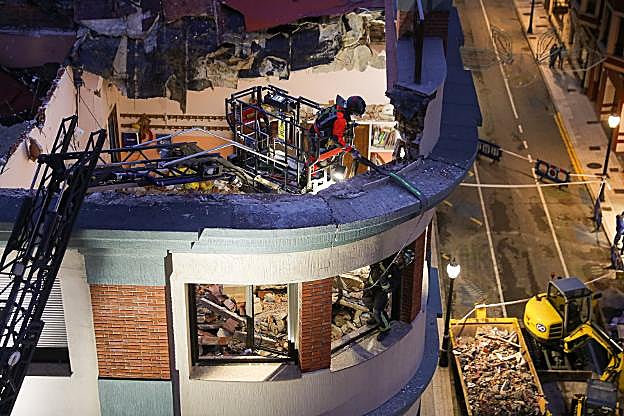 Dos efectivos de bomberos colocan una eslinga en torno al elemento fracturado. 