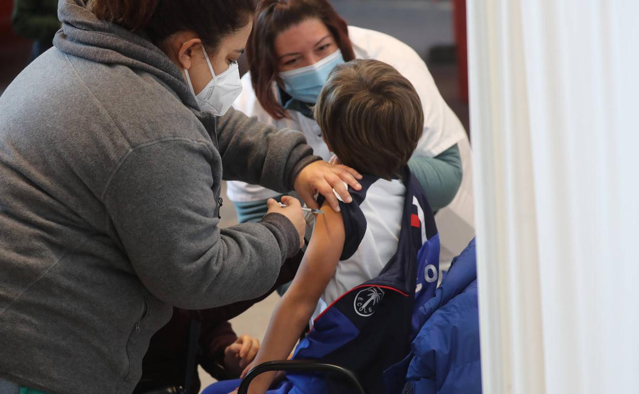Una enfermera vacuna a un niño en el Palacio de Deportes de Gijón. 