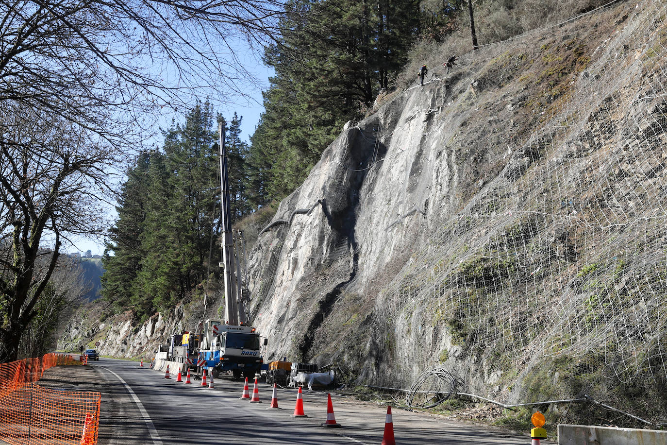 Fotos: Los operarios fijan los bulones y las redes de cotención en la AS-15