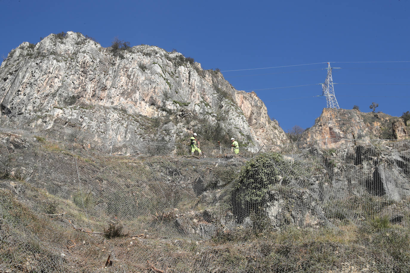 Fotos: Los operarios fijan los bulones y las redes de cotención en la AS-15