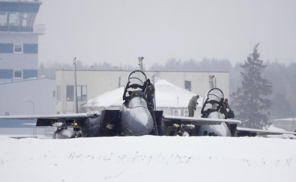 Un técnico barre la nieve de las alas de un caza estadounidense desplegado en Estonia dentro de las fuerzas de la OTAN.