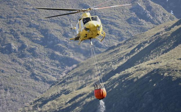 Helicóptero de Bomberos de Asturias durante la extinción del incendio en Ibias. 