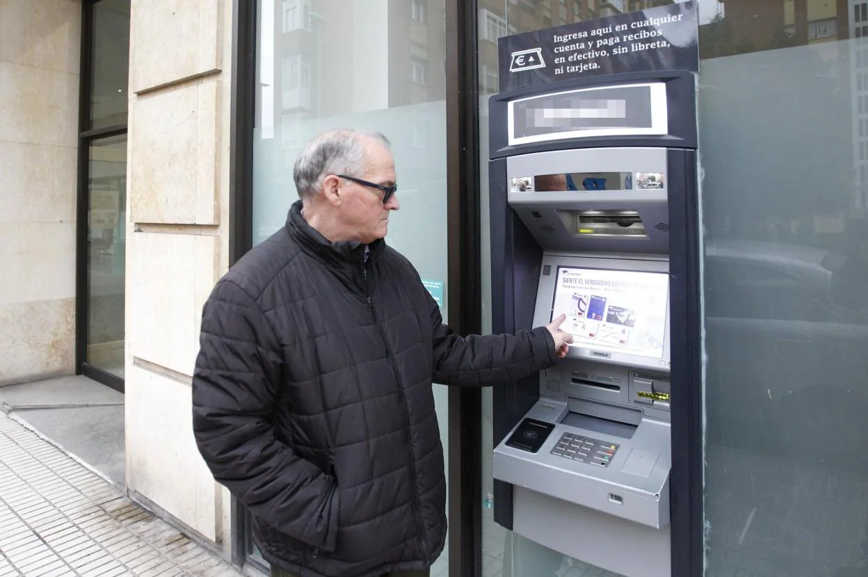 Pedro Carretero, ante un cajero de una entidad bancaria. 