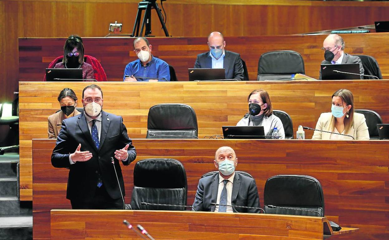 Barbón responde a una pregunta desde su escaño, con parte de los diputados del grupo socialistas detrás.