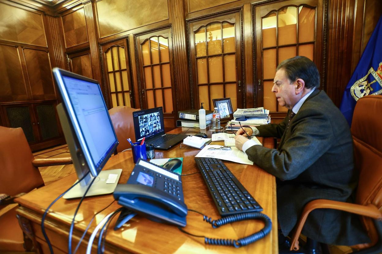 El alcalde, Alfredo Canteli, siguiendo la sesión telemática del Pleno ayer. 