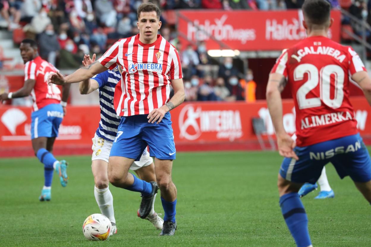 Christian Rivera conduce el balón perseguido por Sergi Enrich. 