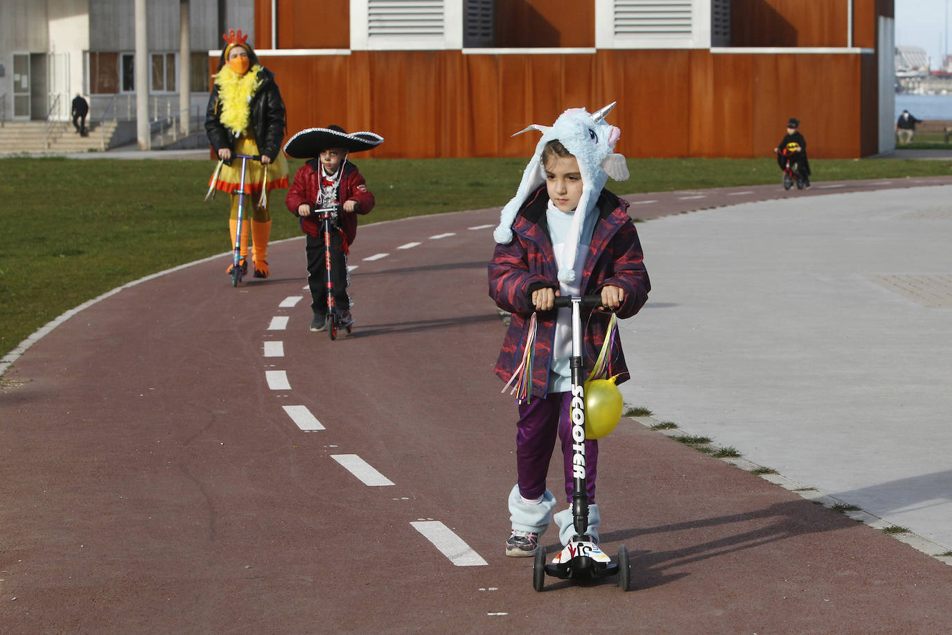 Los más pequeños lucen los disfraces de Carnaval subidos en las bicicletas y monopatines.