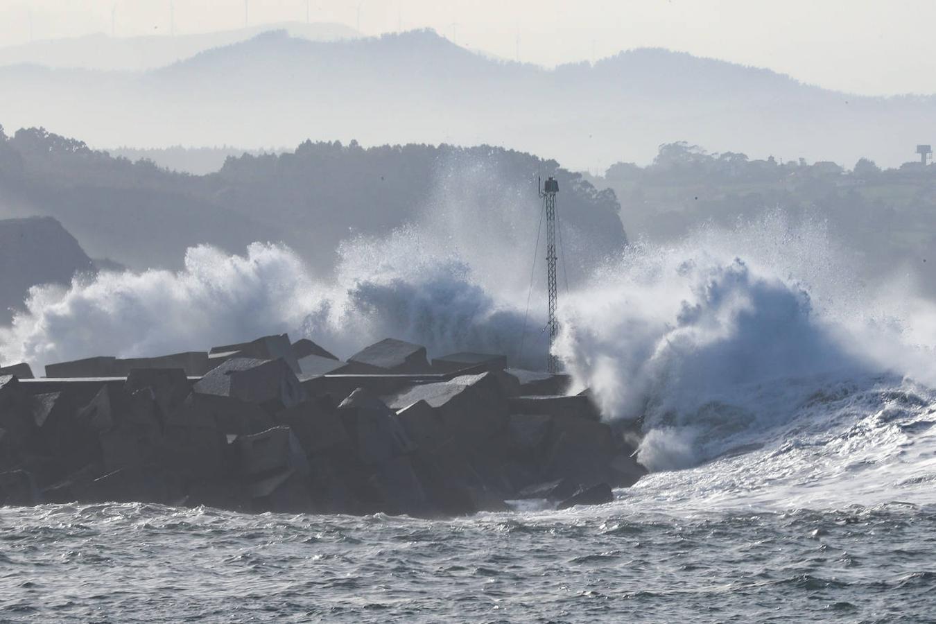 El faro de San Juan de Nieva estuvo rodeado de un fuerte oleaje durante la jornada de este jueves, en Avilés.