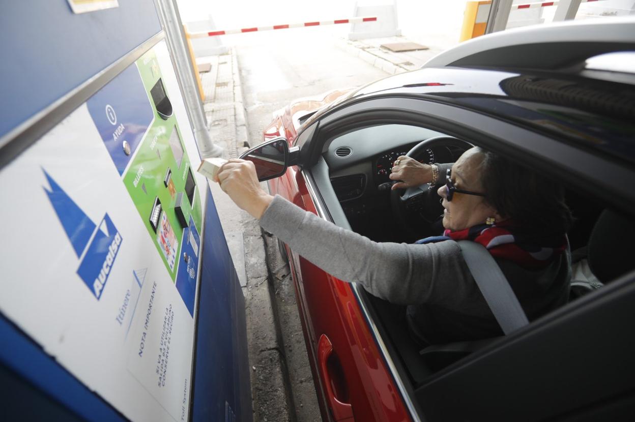 Una usuaria usa una tarjeta para abonar el peaje en una de las cabinas de pago en La Magdalena, en la autopista del Huerna. 