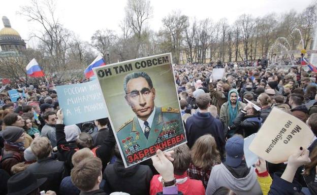 Manifestantes llevan un cartel que representa a Putin como Leonid Brezhnev durante una masiva manifestación de protesta en San Petersburgo, Rusia, en mayo de 2018. 