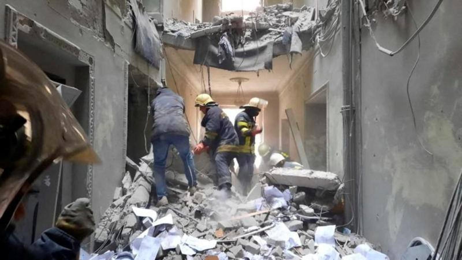 Los servisios de rescate trabajan entre los escombros de un edificio destruido en Járkov.