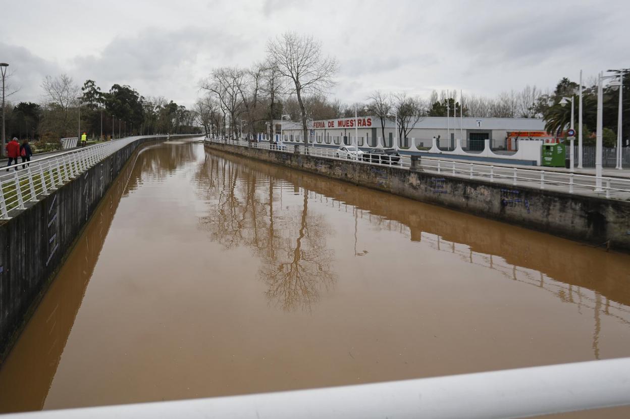 El río Piles, teñido de marrón, a la altura del recinto ferial Luis Adaro. 