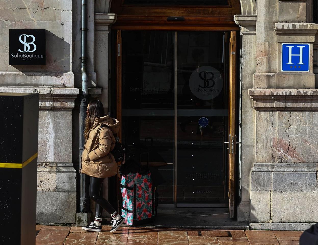Una turista con su maleta, en la puerta de entrada de uno de los hoteles del centro de la ciudad, ayer. 