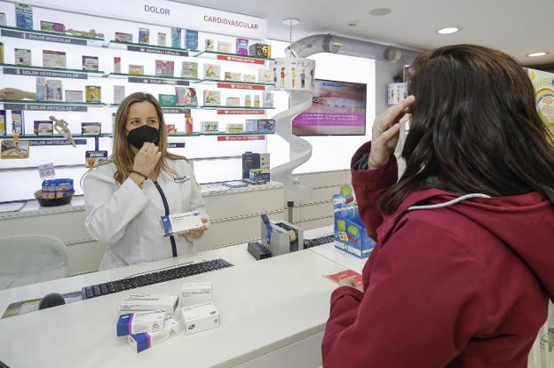 La farmacéutica Andrea Vallín, de la Farmacia Castillo, despacha un ansiolítico a una mujer. 