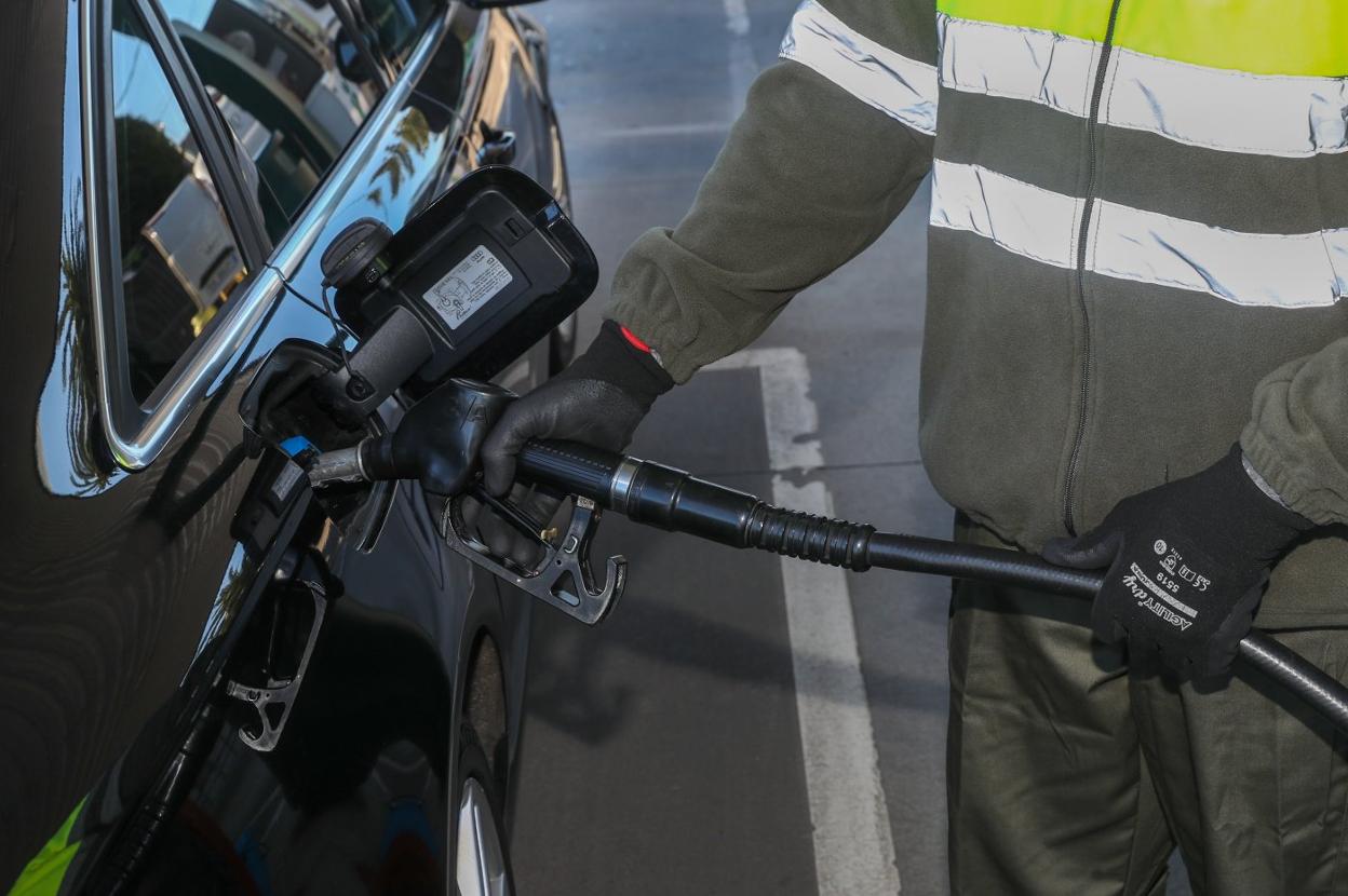 Un empleado de una gasolinera de Gijón suministra combustible a un cliente. 