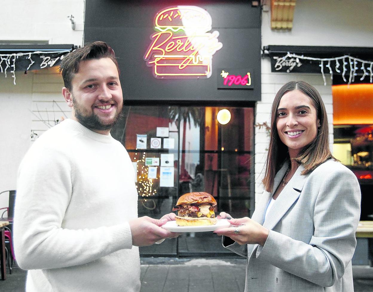Alberto García y Lucía Álvarez, en la puerta de su negocio gijonés, con la hamburguesa premiada. 