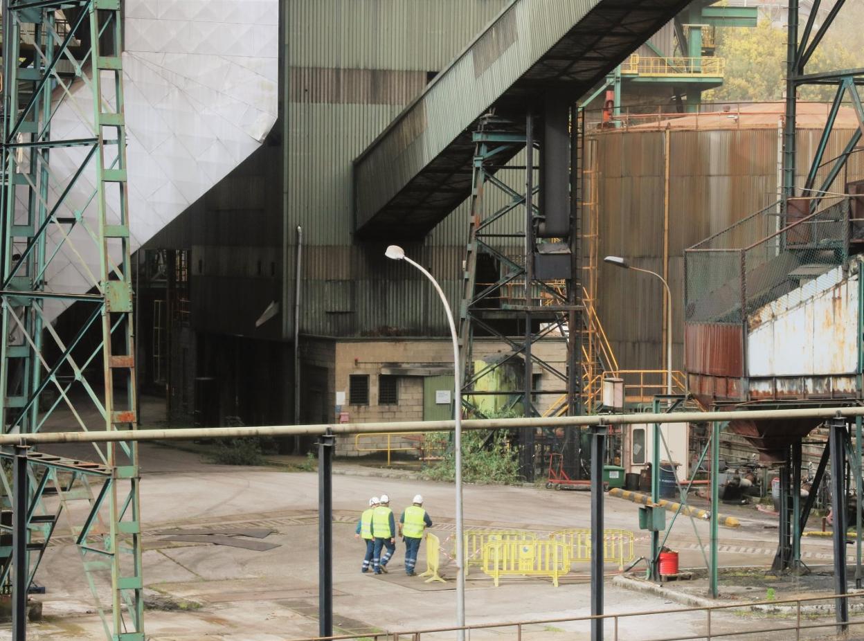 Trabajadores de Lezema Demoliciones S. L., con vallas, en la central térmica de Soto de la Barca. 