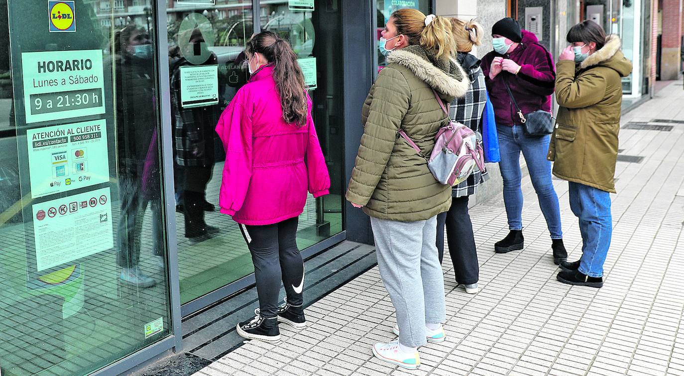 Galería. Clientes a la puerta de un supermercado cerrado ayer en Gijón por la falta de suministros.